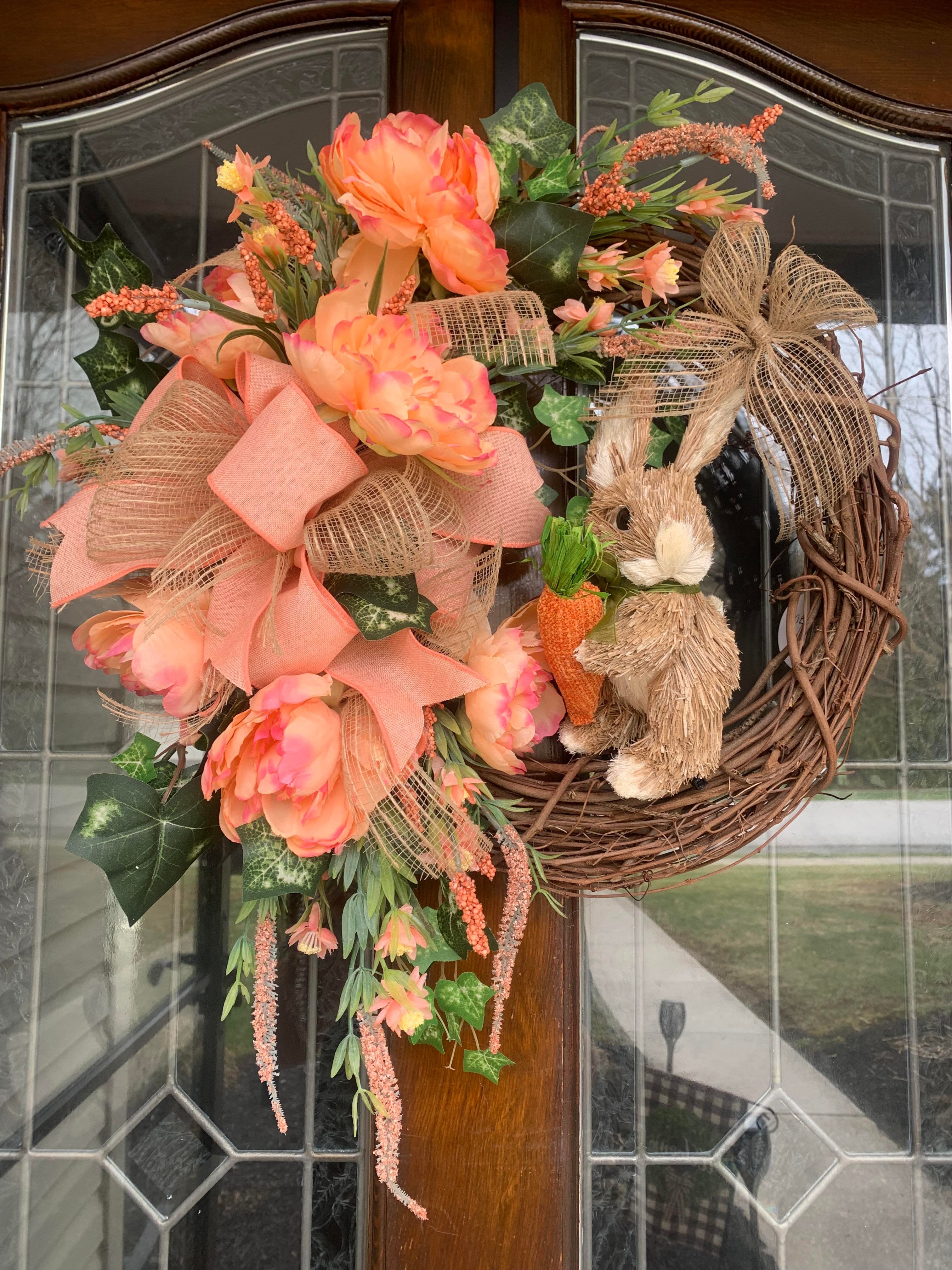 coral blooms and bow on a grapevine wreath with grass bunny