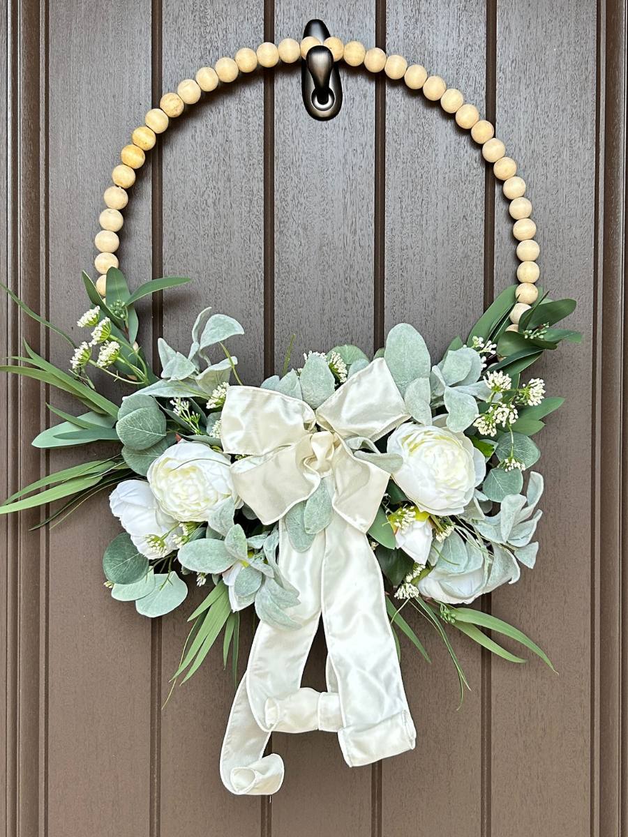 wood bead wreath with cream peonies and cream ribbon