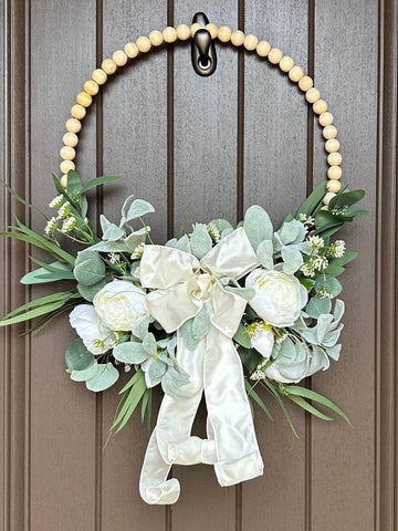 wood bead wreath with flowers and a bog