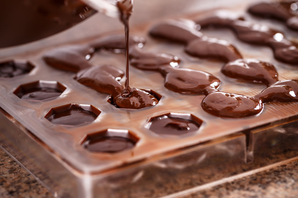 Homemade CBD chocolate being poured into chocolate moulds