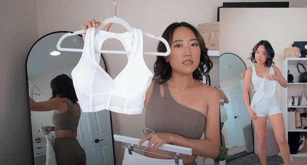 Amy Sun shows everyone a white sports bra paired with a white A-line skirt