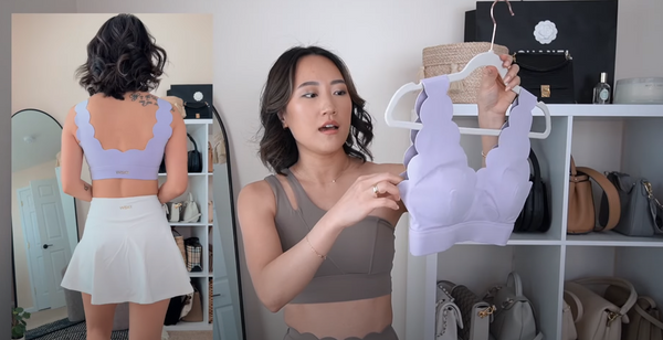 Amy Sun shows everyone a purple sports bra paired with a white A-line skirt