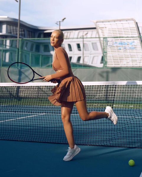 A model wearing WISKII activewear while playing tennis.