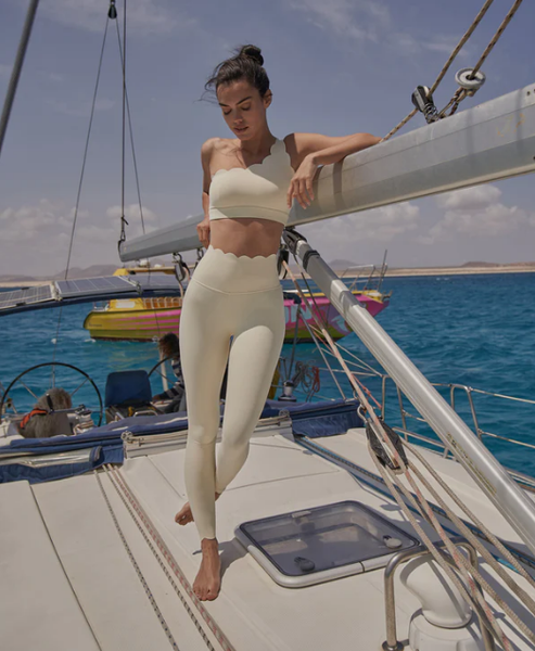 The model showcases WISKII's seamless sports bra and leggings on a boat.