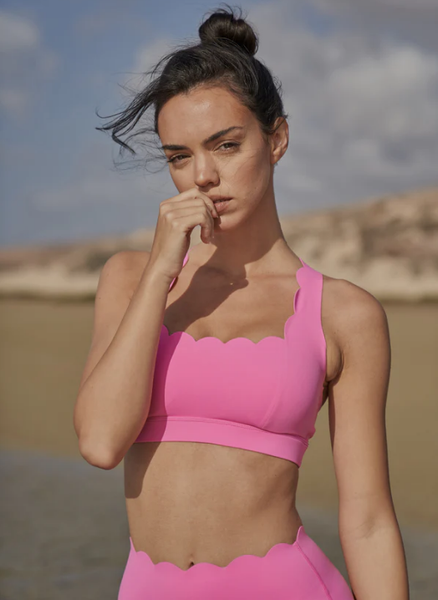 The model showcases the pink WISKII seamless sports bra in the Gobi Desert