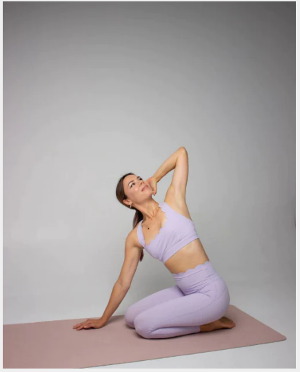 Model wearing purple CROSS BACK SPORTS BRA practicing Pilates