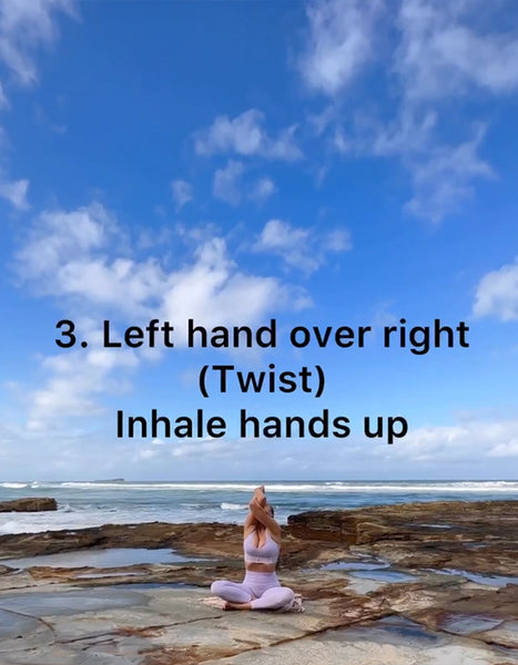 A model wearing a purple WISKII yoga set practicing FORWARD FOLD WITH ARM VARIATION by the seaside.