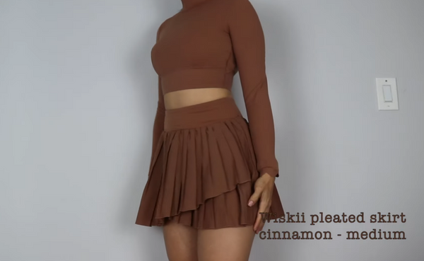 Julissa Pacheco shows off a flowing pleated skirt in cinnamon and a top in the same color