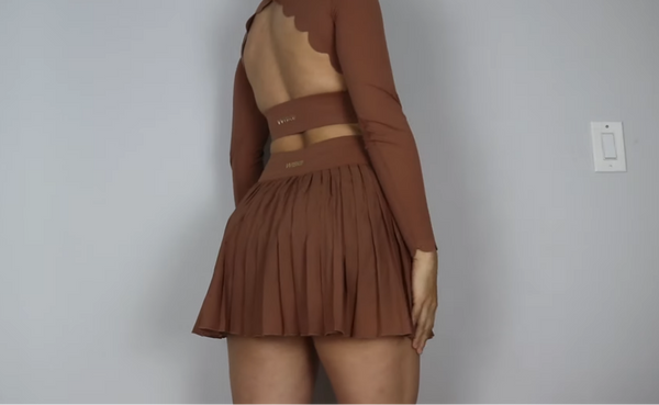Julissa Pacheco shows off the delicate back design of a flowing pleated skirt in cinnamon and a matching top