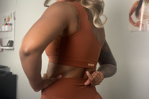 Autryana McGee is showing the details of DYNAMIC ONE SHOULDER SPORTS BRA