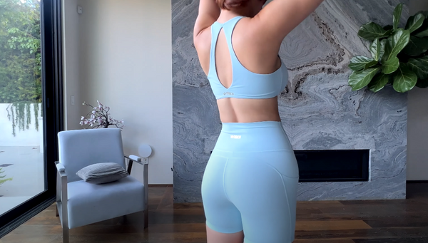 Brandy G is showcasing the cut-out design on the back of the blue yoga bra.