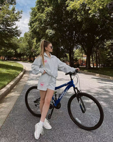 A model wearing WISKII's casual wear while riding a bike in the park.