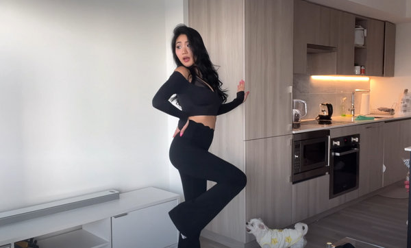 Lena Joo showcasing the dreamy black workout long-sleeve top paired with black flare leggings.