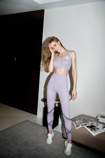 The model is showcasing purple yoga attire.