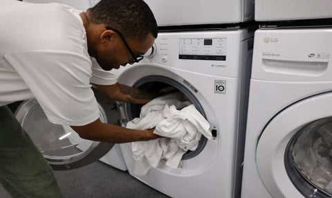adding clothes to washer