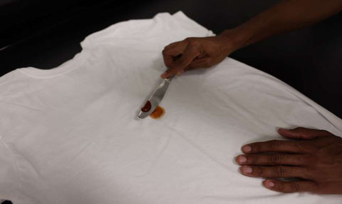 scraping ketchup off of white tee