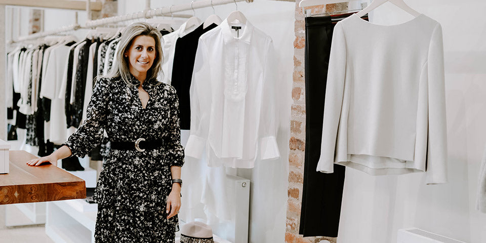 Abi Fisher stood at the shop in Cheshire with clothing in the background