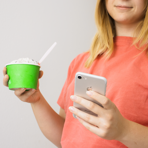 Women holding ice cream and phone