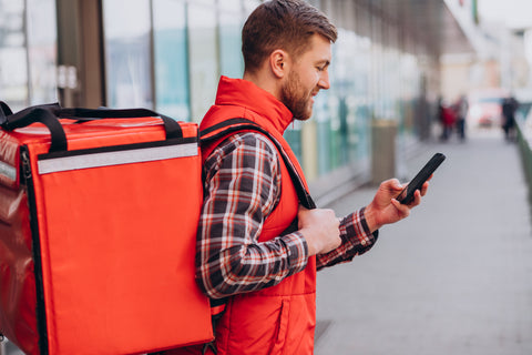 A delivery guy looking in his phone