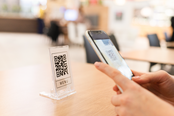 person scanning QR code to pull up menu