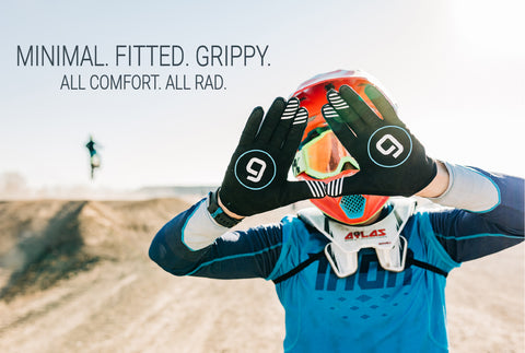 A motocross rider with his hands up, palms out, showing his Gripit glove.