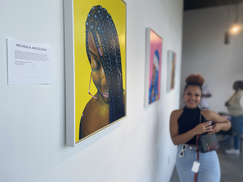 Micheala Angelena standing next to her painting "Box Braid Babe" at the Houston Mixed Media Festival