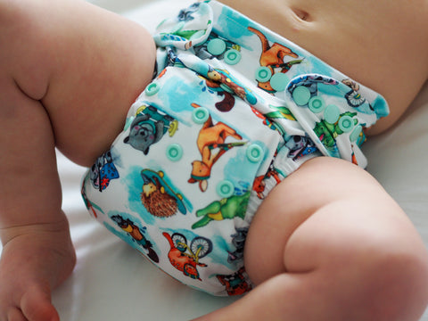 Baby wearing a colourful cloth nappy featuring Aussie animals