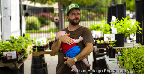 jay beard holding baby at farmers market