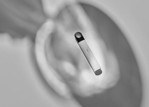 A white RELX Essential vape device on a white background with shadows.