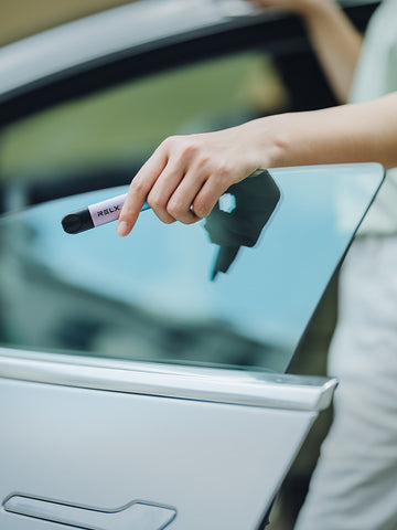 A woman holds a RELX device in her hand.