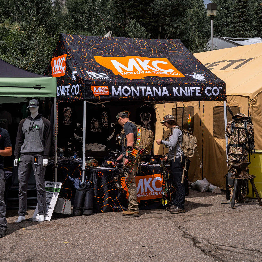 A Montana Knife Company vendor tent is at an outdoor event.