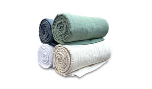 The SONU Muslin Blanket, photo of white, ivory, sage and pacific colors.