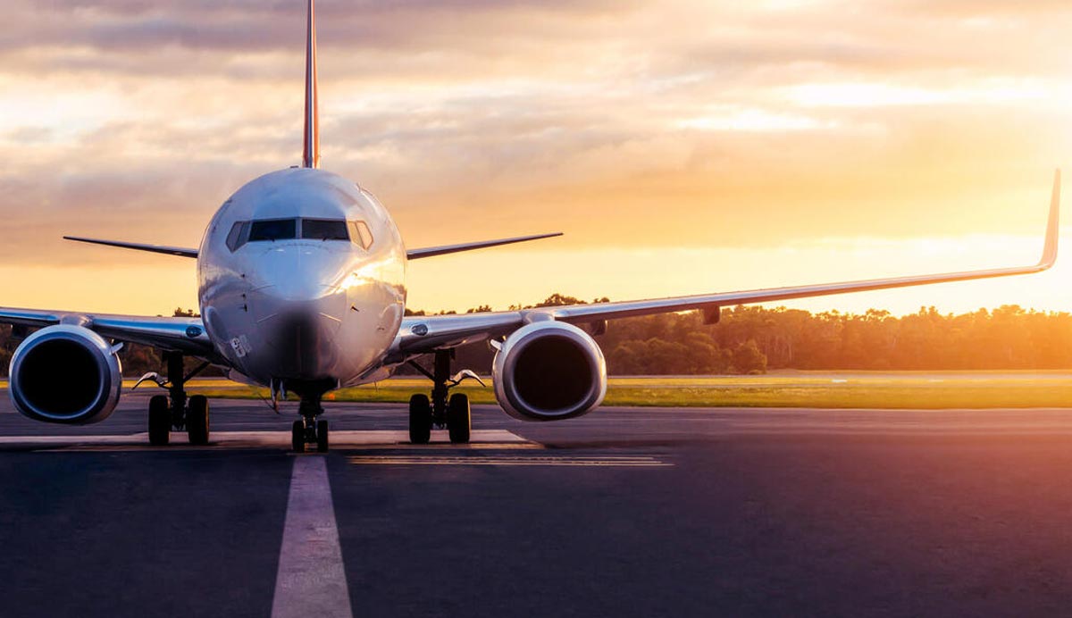 Photo of an airplane on the runway at sunset.