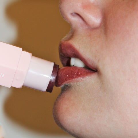 Woman applying Violet Jrdan glow & go berry stick on lips