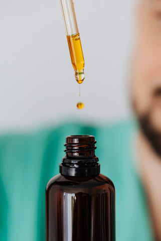 cbd dropper dropping cbd into a tincture bottle