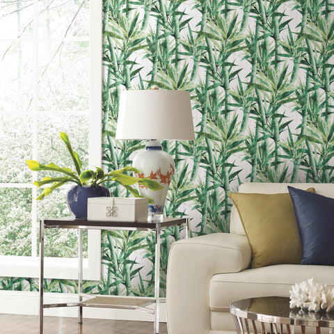 Green RoomMates Lucky Bamboo Peel and Stick Wallpaper on the wall in a sitting area with a tan couch and decorative side table.