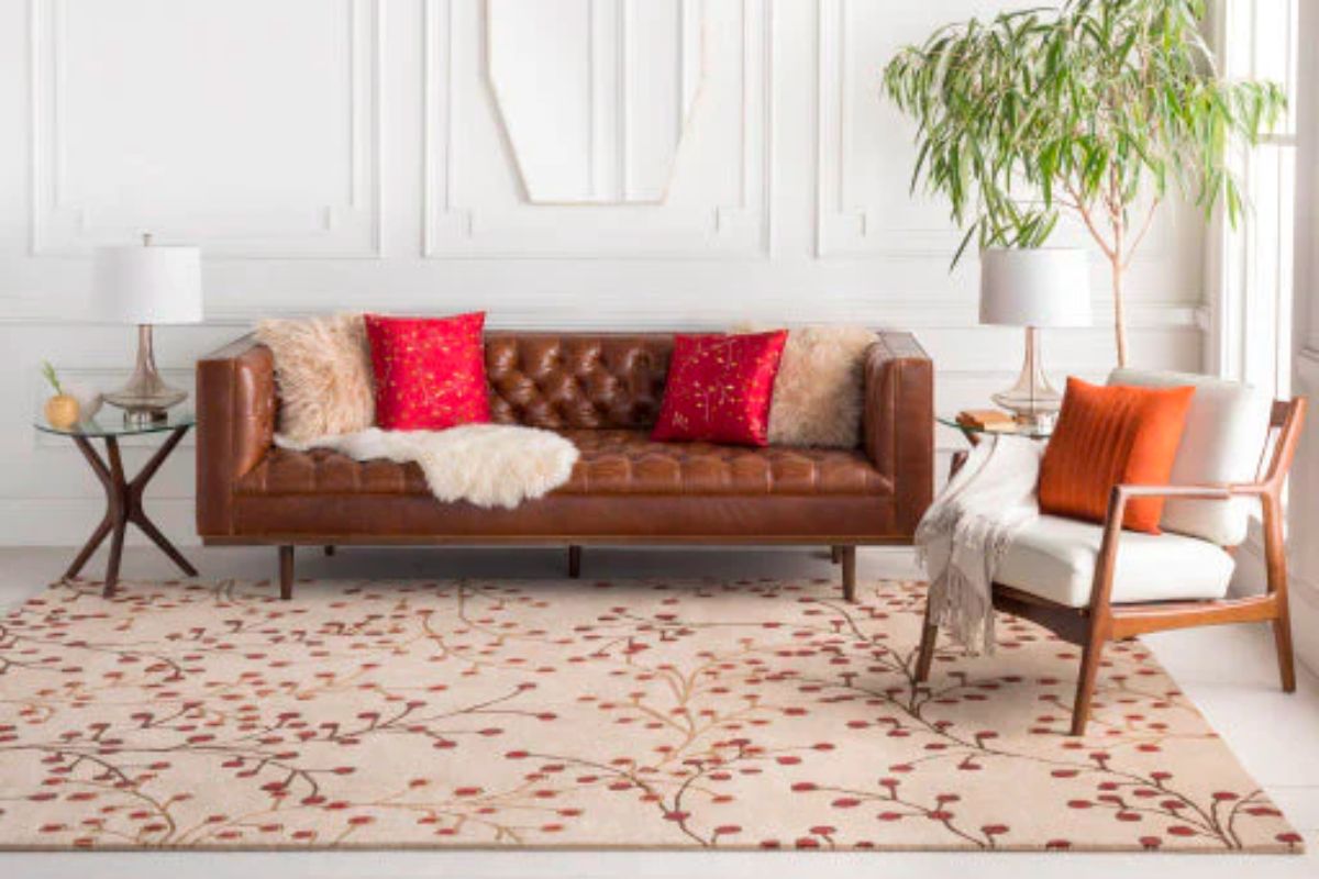 Patterned Surya area rug in a room with couch and chair.