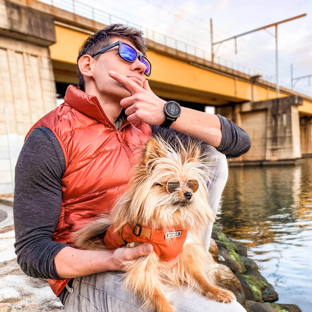 Dog and owner posing by water wearing Pipco puffer jackets Australia