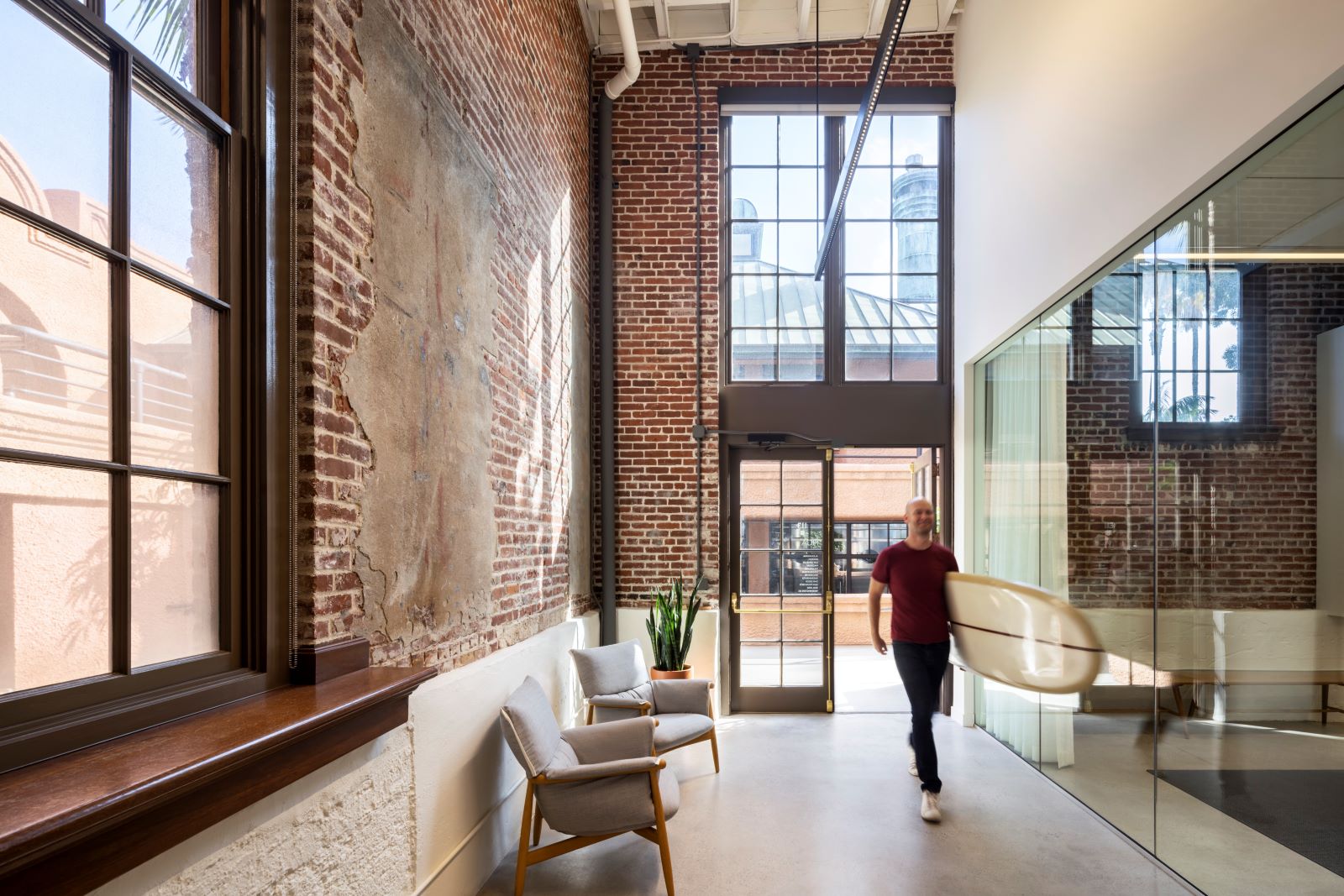 Photo of HGA offices in San Francisco - man carrying a surfboard into the office at the front