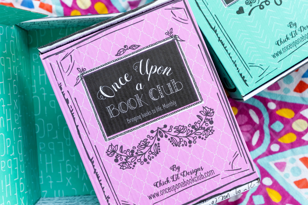 OUABC Book subscription boxes with a colorful fabric background.