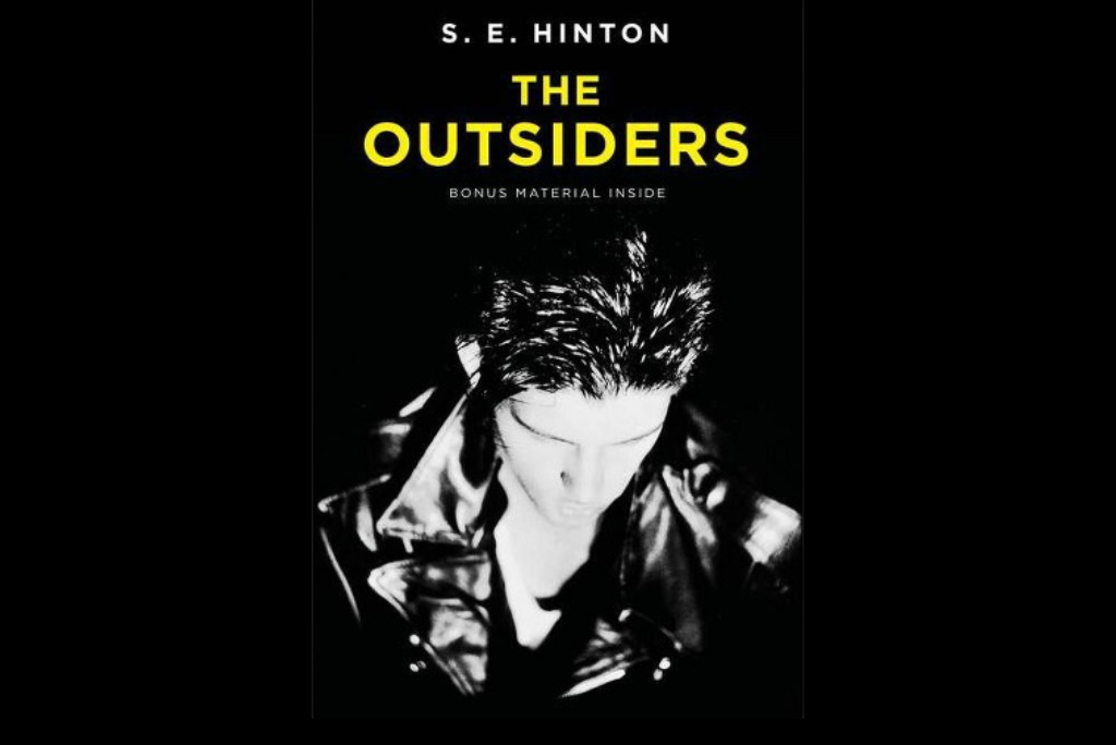 Cover of 'The Outsiders' book by S.E. Hinton featuring a dark figure.