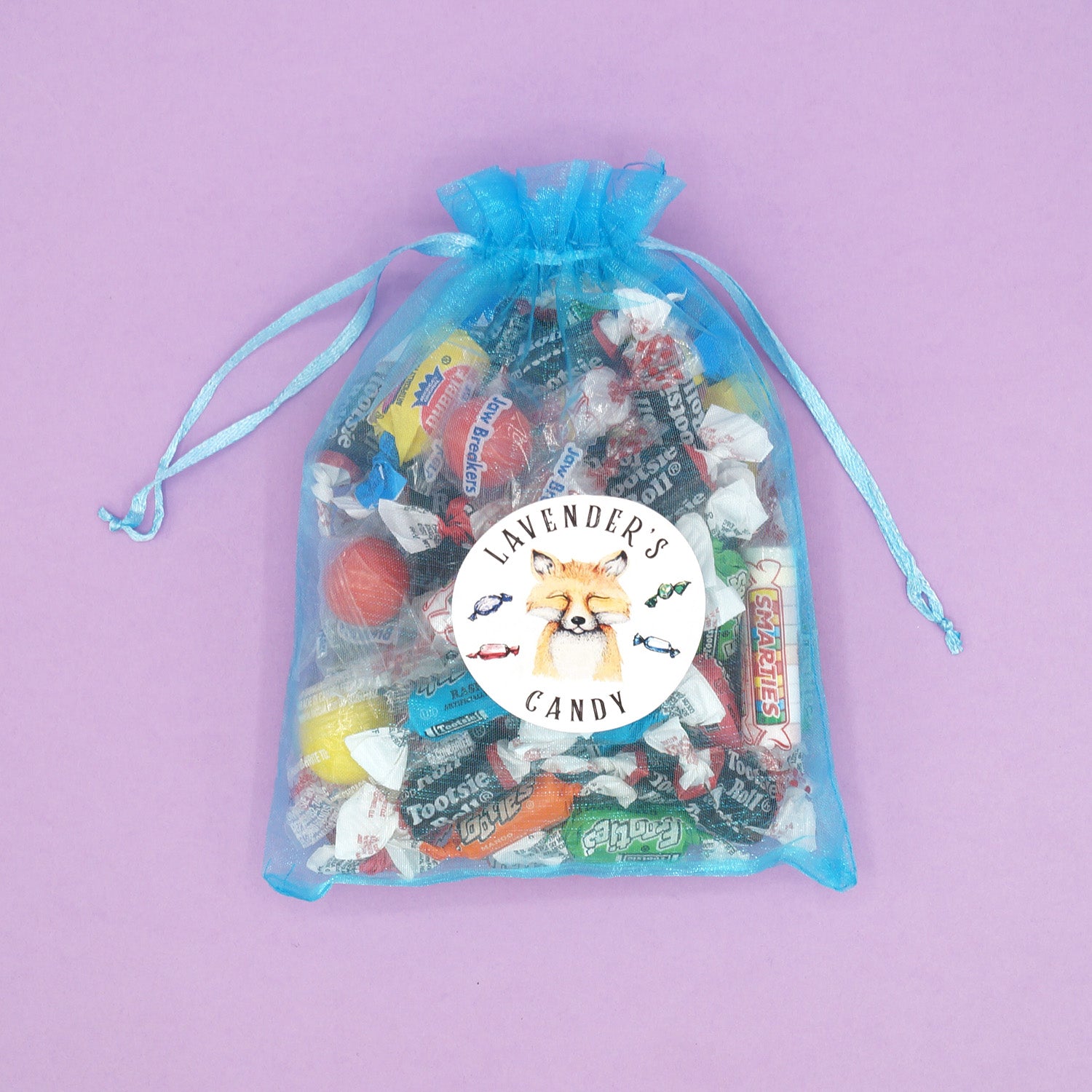 A teal organza bag filled with candy. The sticker on the front says Lavender's Candy.