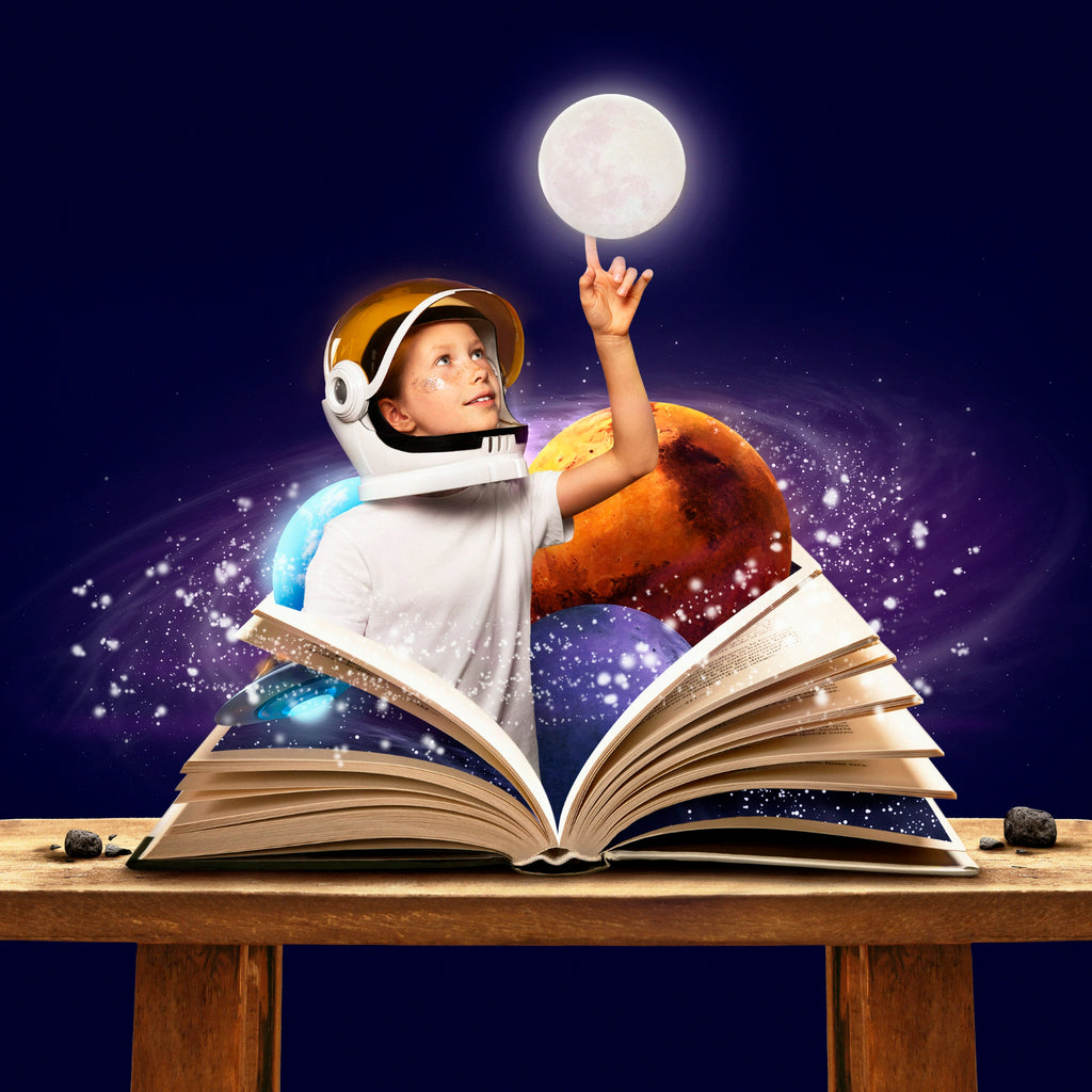 A child in astronaut gear reaches for the moon emerging from the pages of an open book, blending reality with the imagination against a starry space backdrop.