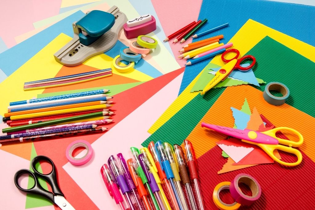 Colorful craft supplies on a multicolored background, ready for creative projects.