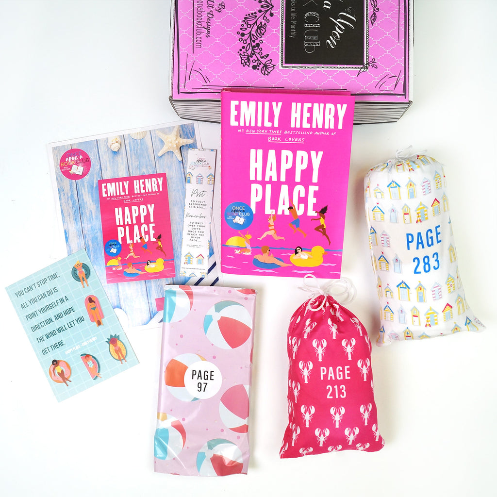 Collection of items from 'Happy Place' by Emily Henry, including the book, themed pouches, bookmarks, and postcards, arranged on a white surface.