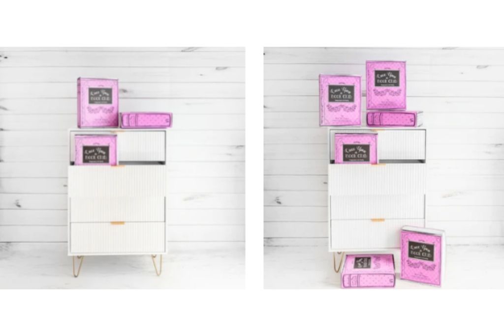 Pink book subscription boxes arranged on and around a white cabinet against a wooden backdrop.