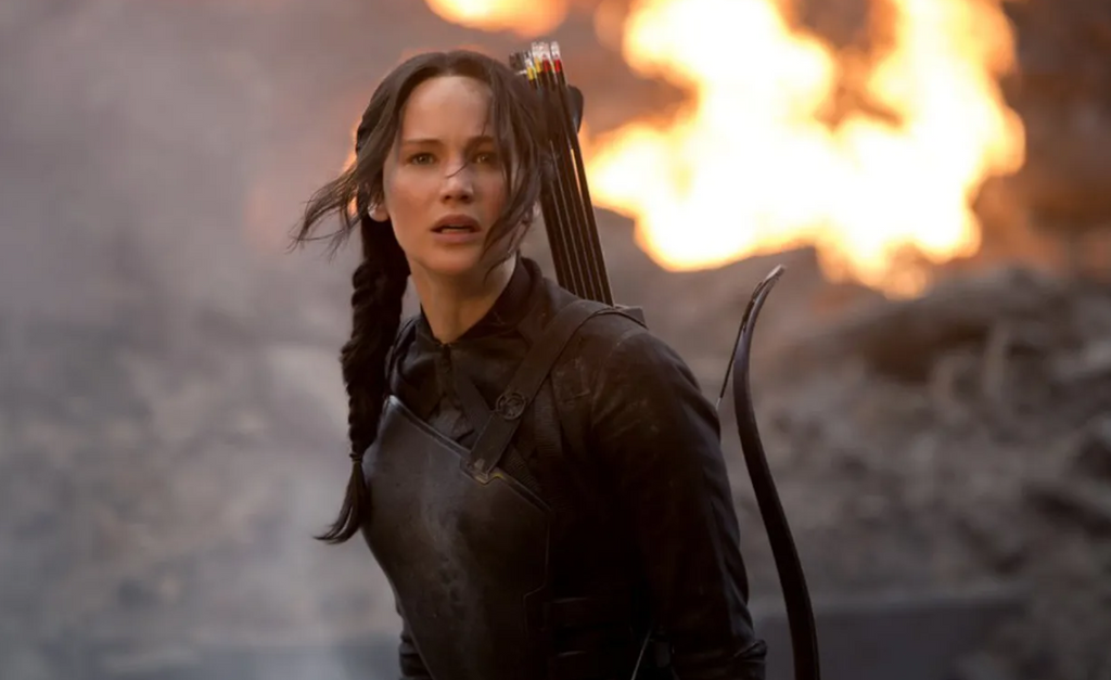 The Hunger Games- A young girl with a bow and arrows strapped to her back.