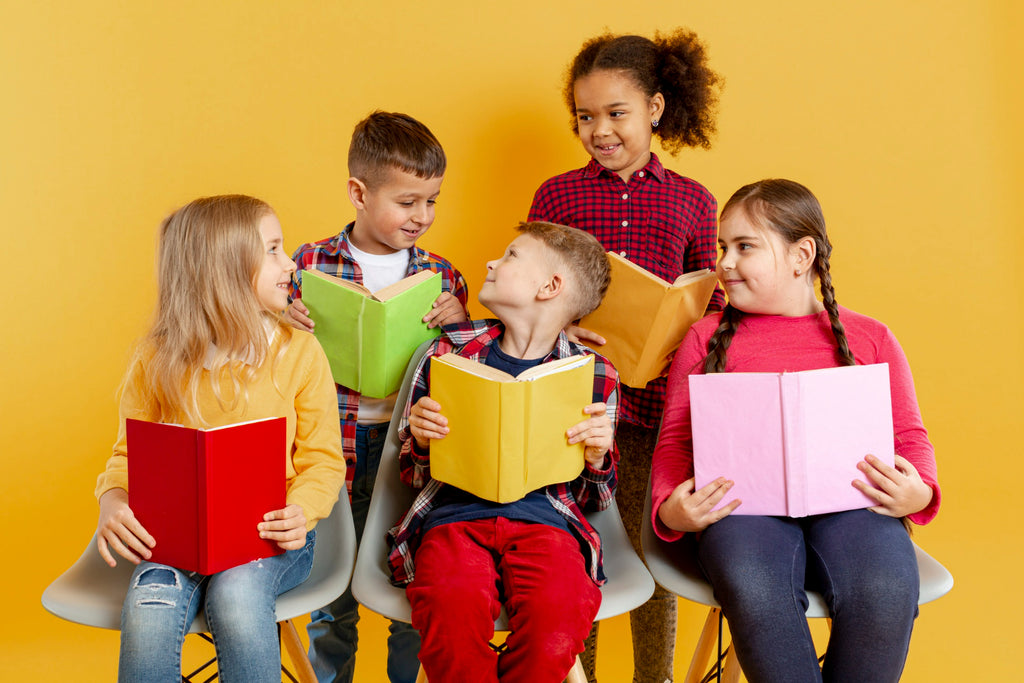Five children with vibrant books sit together, engaging with each other over their reading material against a warm yellow background.