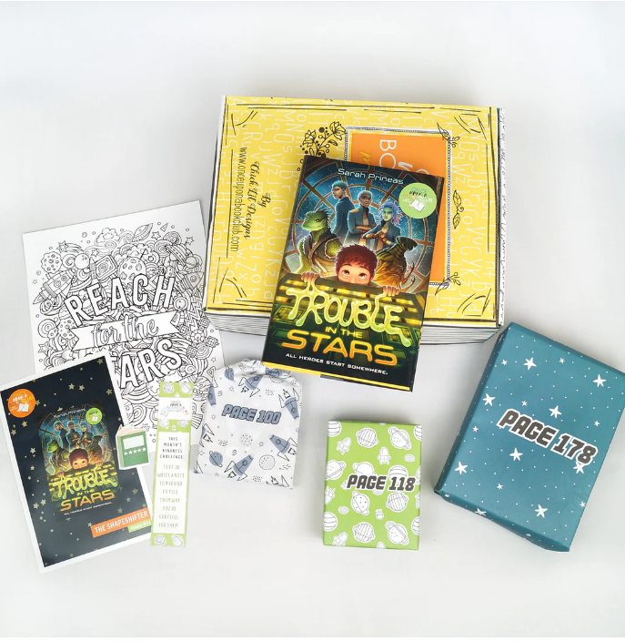 An assortment from "Once Upon a Book Club" featuring "Trouble in the Stars" by Sarah Prineas, with related gifts and an activity sheet, all designed to enhance the interactive reading adventure for young readers.