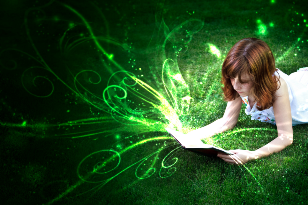 Girl reading a book with glowing green magical swirls on grass